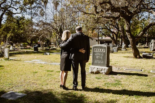 A Couple Standing In Front of a Tombstone
