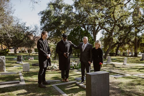 Free People Weraing Black and Standing Over a Grave  Stock Photo