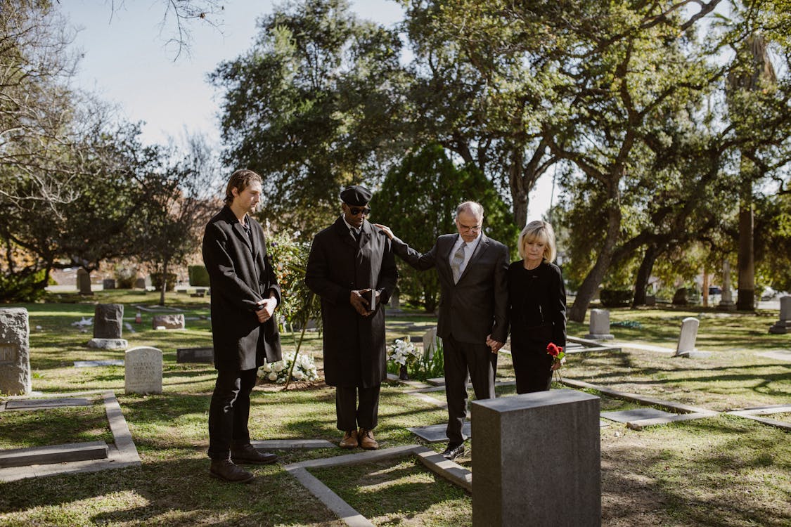 Free People Weraing Black and Standing Over a Grave Stock Photo