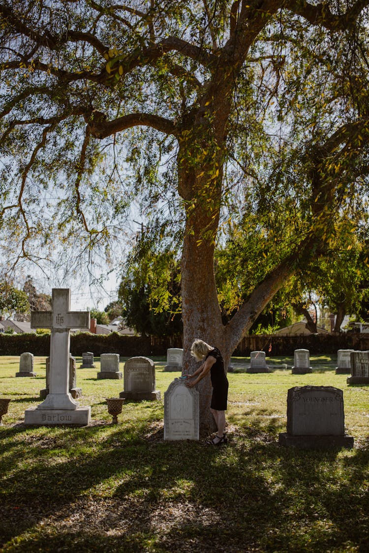 Woman Standing Beside A Gravestone 