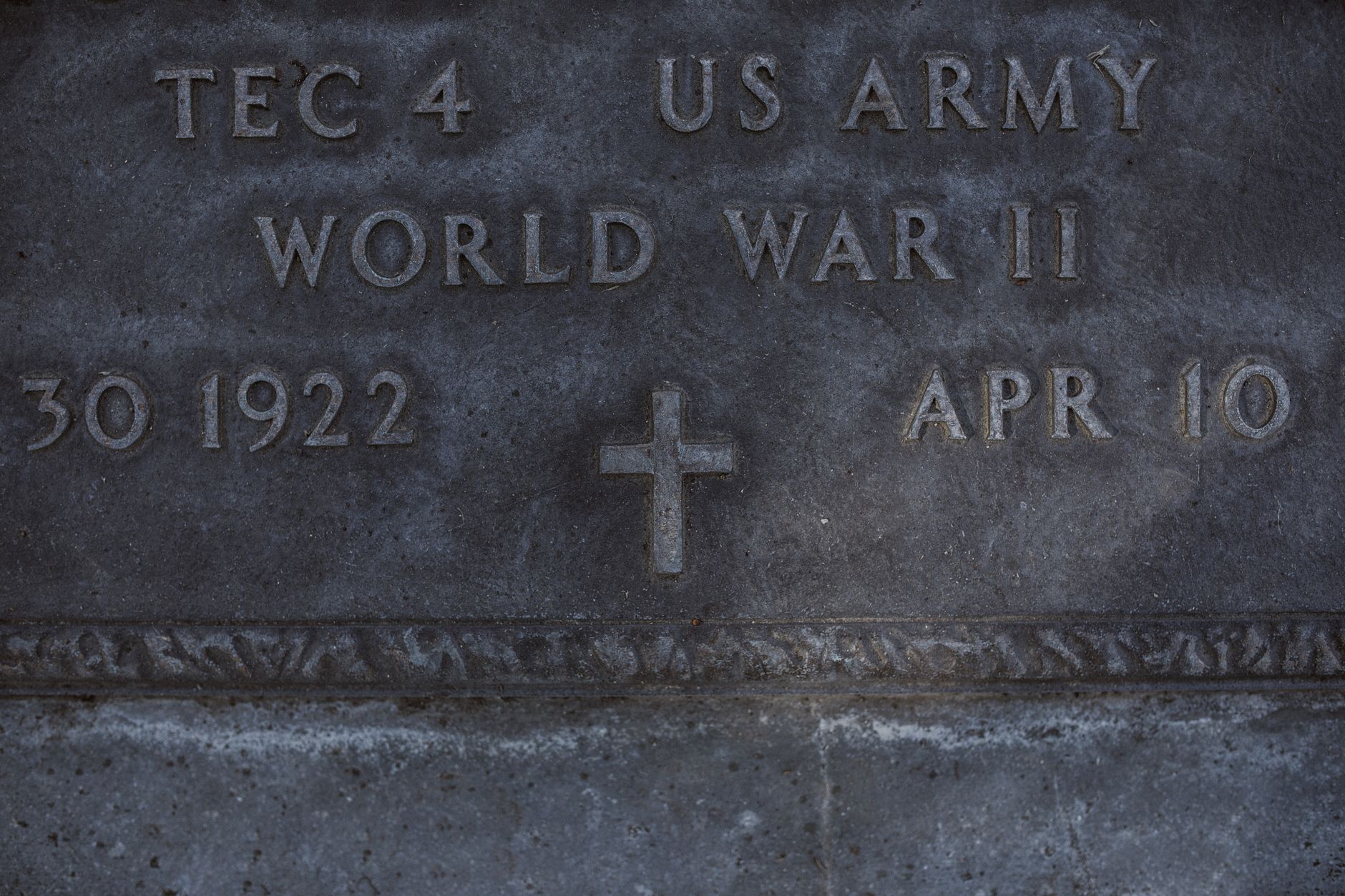 Close-up view of a US Army World War II veteran's gravestone with details engraved.