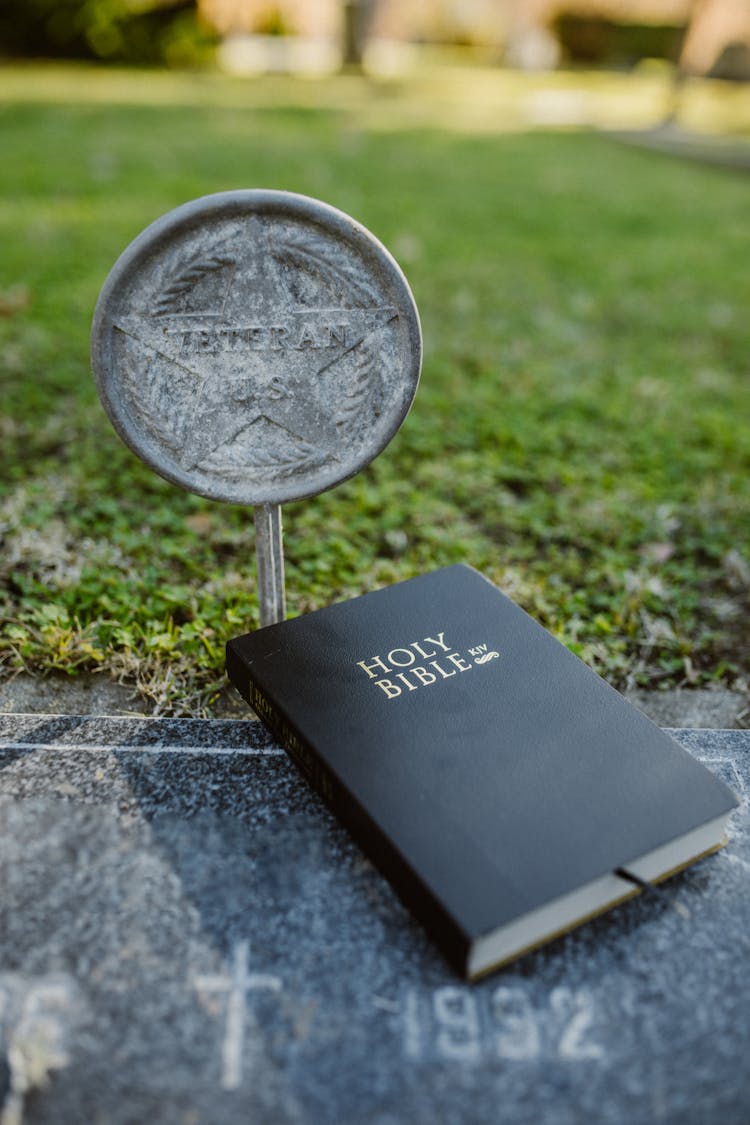 

A Bible And A Veteran Grave Marker On A Grave