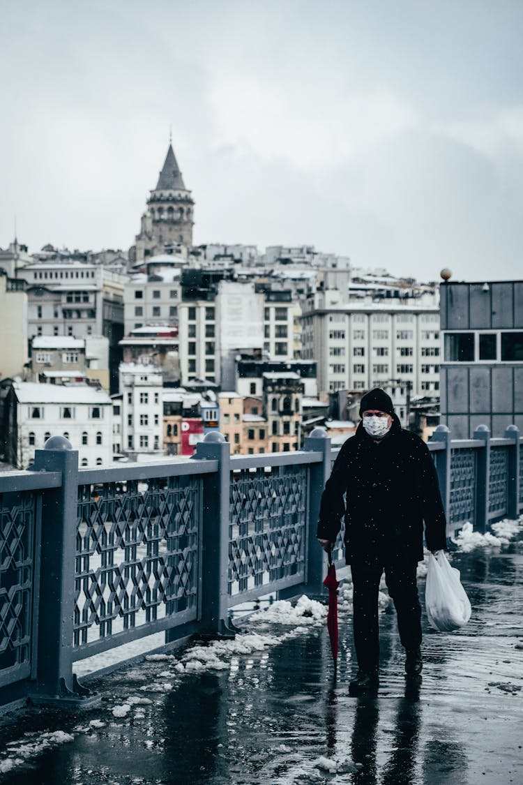 Man In Medical Mask Walking On Walkway In Winter City