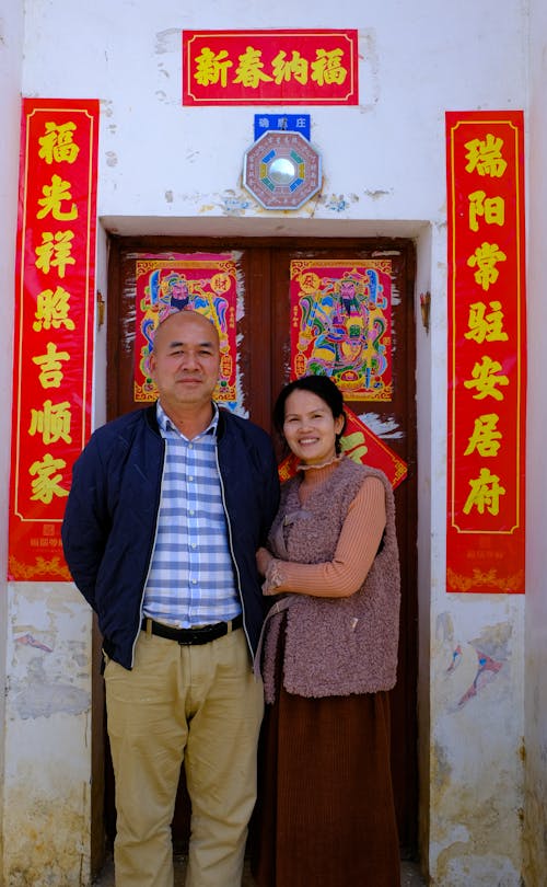 Couple Standing in front of the Door Decorated for Vietnamese New Year Celebration 