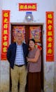 Couple Standing in front of the Door Decorated for Vietnamese New Year Celebration