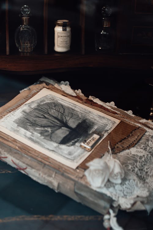 Artwork with artificial flowers against jar and decanters