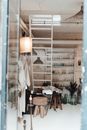 Collection of vases on shelves against plant sprigs and stools on floor in old shop