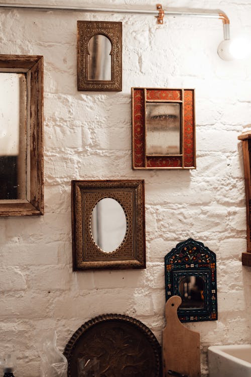 Retro mirrors in decorative frames on rough wall