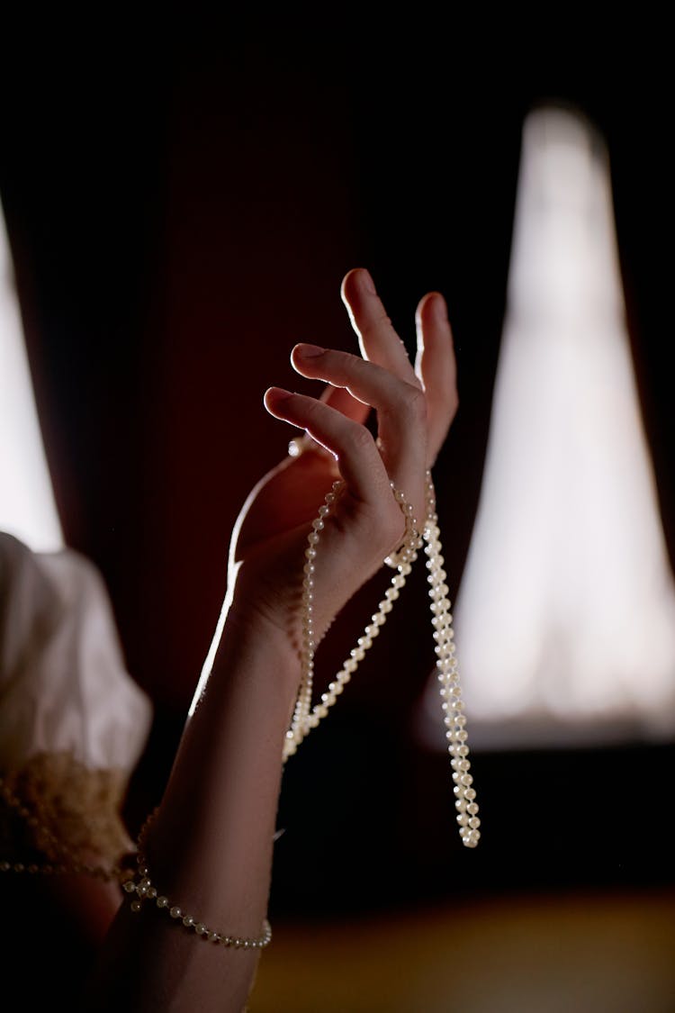 A Person Holding A String Of Pearls