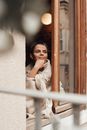 Smiling woman looking out of window at home