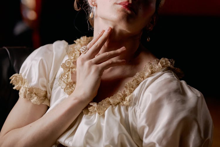 A Woman With Ring Touching Her Neck