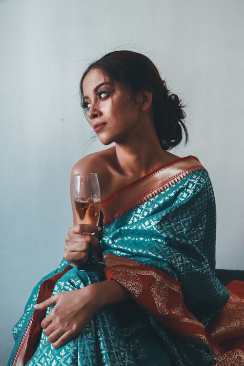 A Woman Wearing One shoulder Top Holding a Champagne Glass