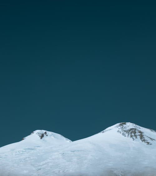 Snowy mountain peak against blue sky