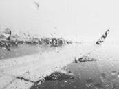 透过雨窗拍摄的黑白机翼画面，捕捉到了雨中旅行的本质