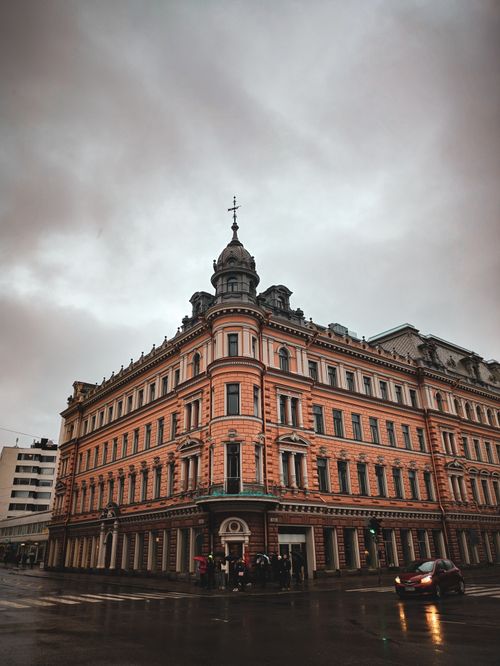 Free A historic architectural building on a street corner under a dark, overcast sky at dusk. Stock Photo
