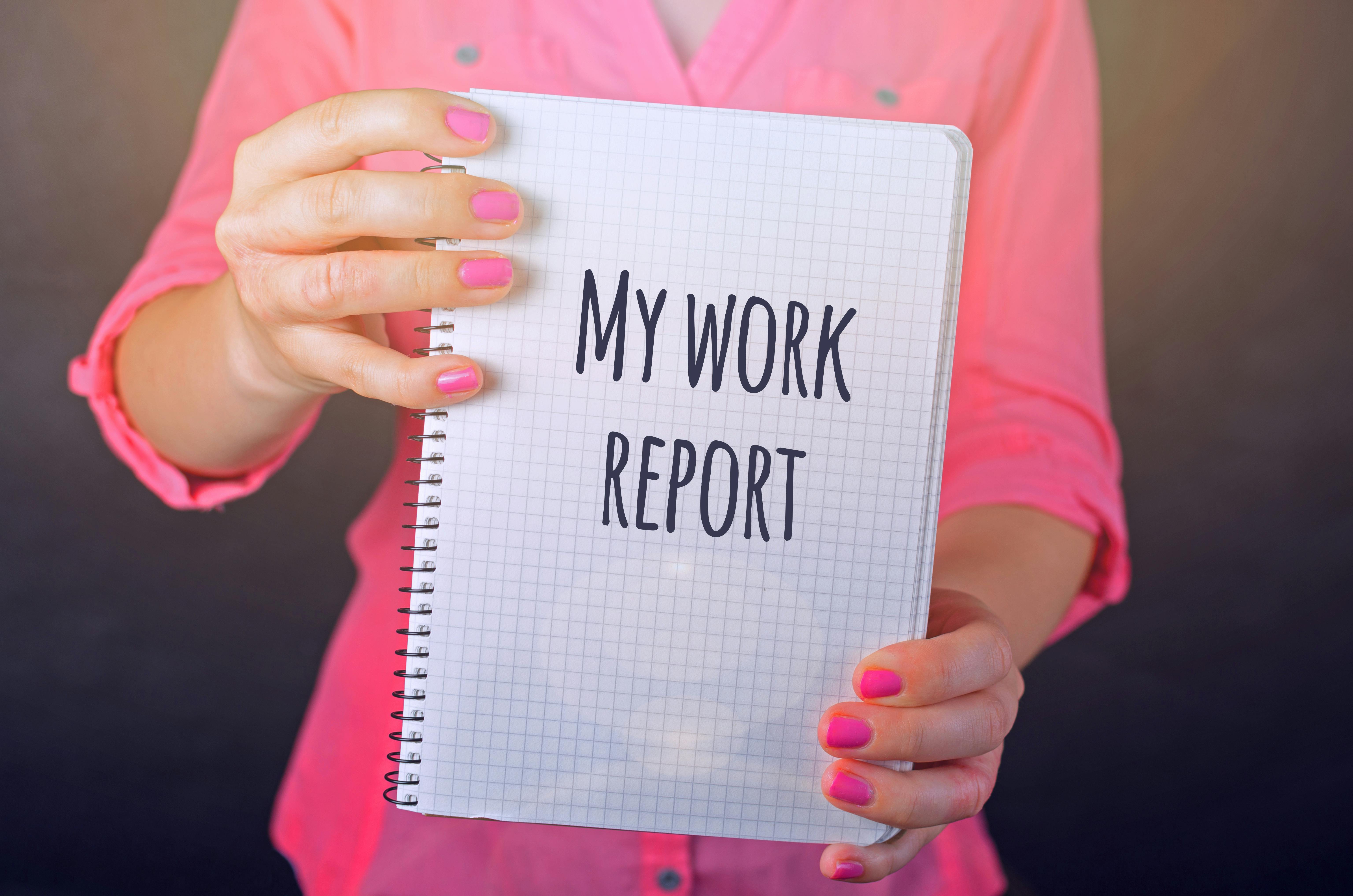 woman in pink long sleeved shirt holding white book with my work report text print