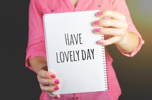 一位穿着粉红色衬衫的女子拿着笔记本，上面写着“度过美好的一天”，传达出积极的态度