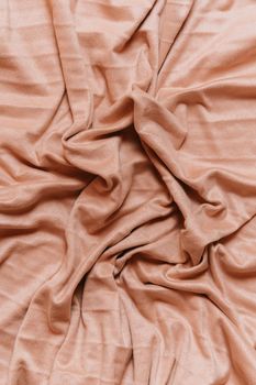 A detailed shot of soft pink satin fabric with elegant wrinkles and folds.