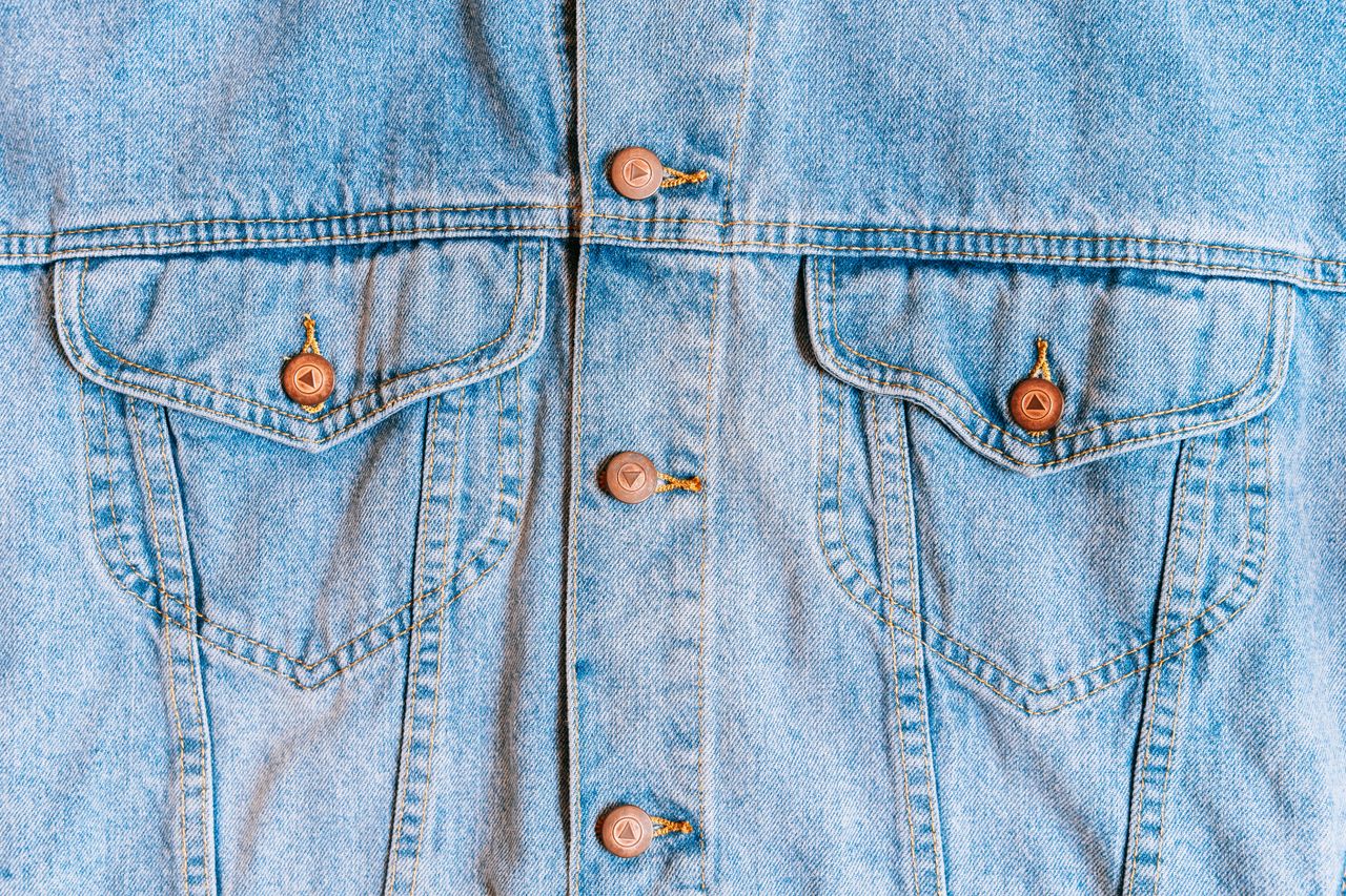 high resolution close up of a denim jacket showcasing button and pocke