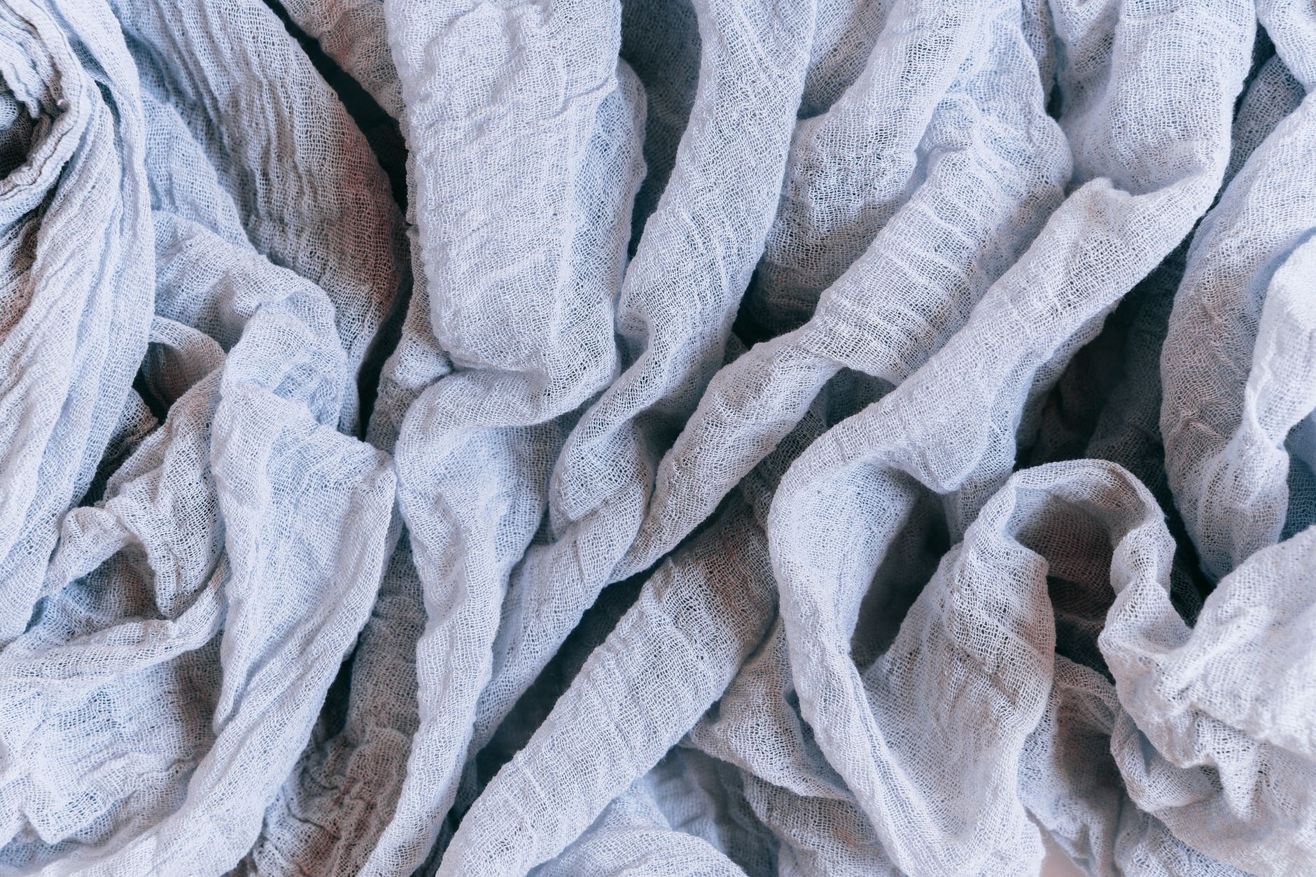 A linen garment showing visible wear and thinning at high-friction areas like elbows and underarms