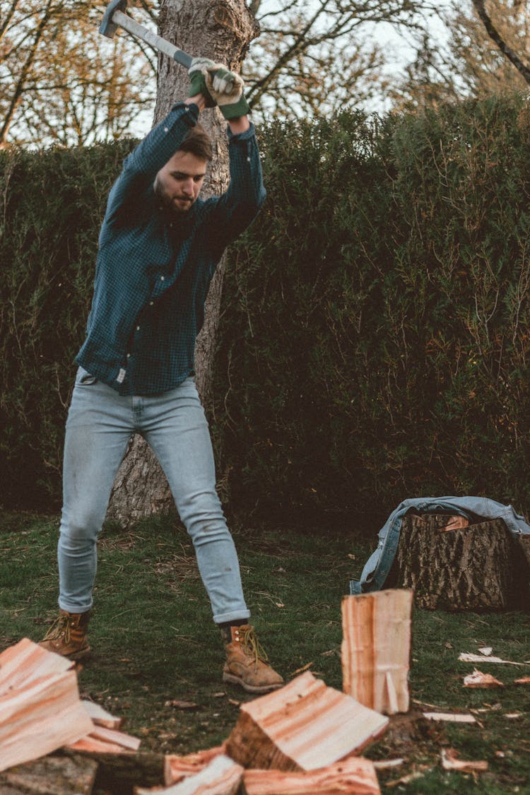 Man With Axe Preparing To Chop Wood On Meadow