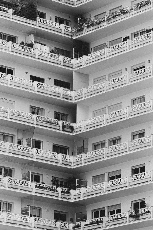 Free Black and white corner of modern multistory residential house with many balconies and metal fences located on street of city Stock Photo