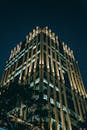 一座引人注目的现代塔楼在夜间点亮灯光，展现了时尚的建筑与城市设计