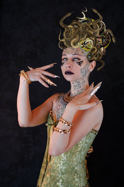 Graceful young lady in Gorgon costume looking at camera