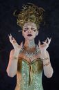 Eccentric woman in Medusa Halloween costume looking at camera in studio