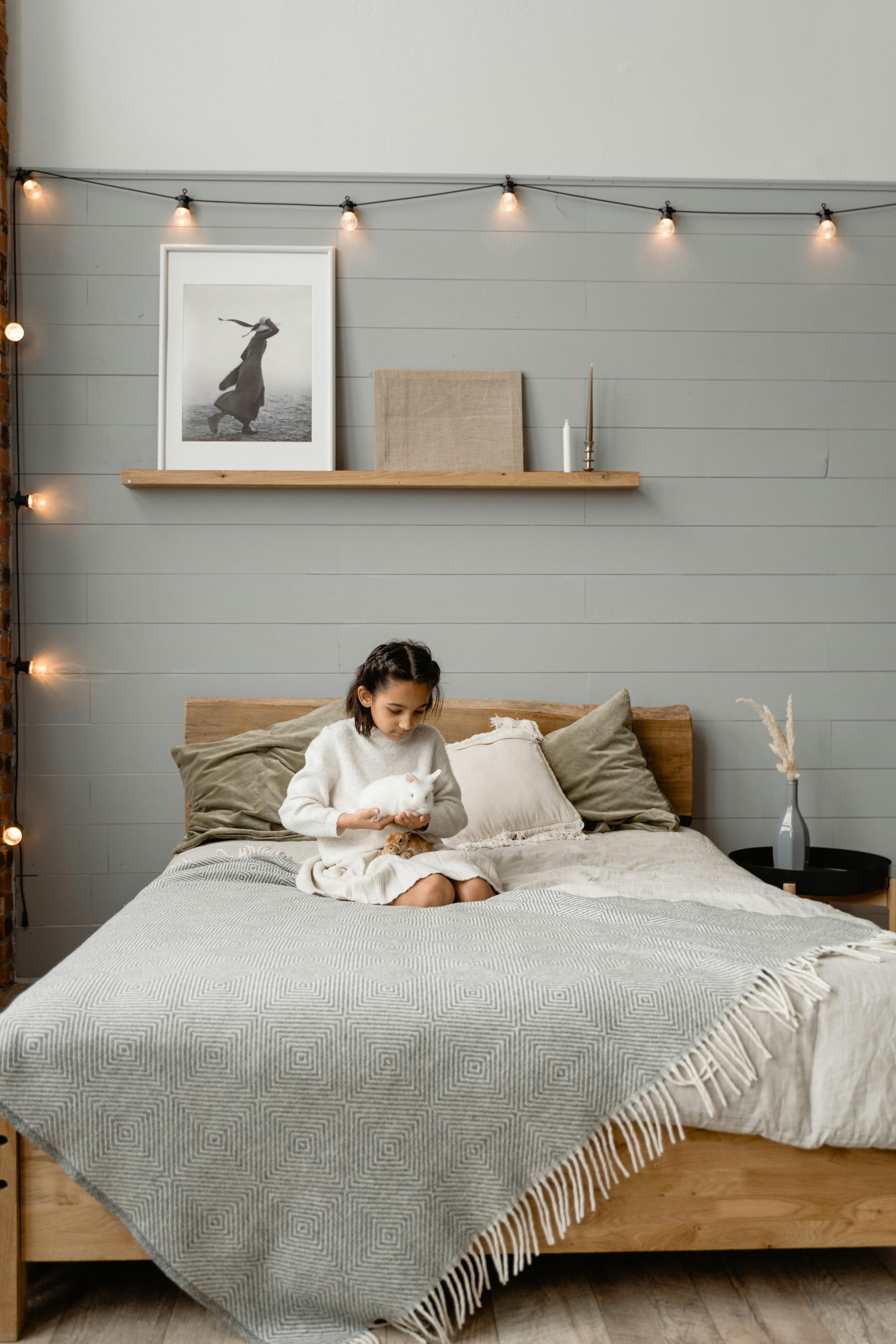 A Woman Sitting on Bed Holding a White Rabbit