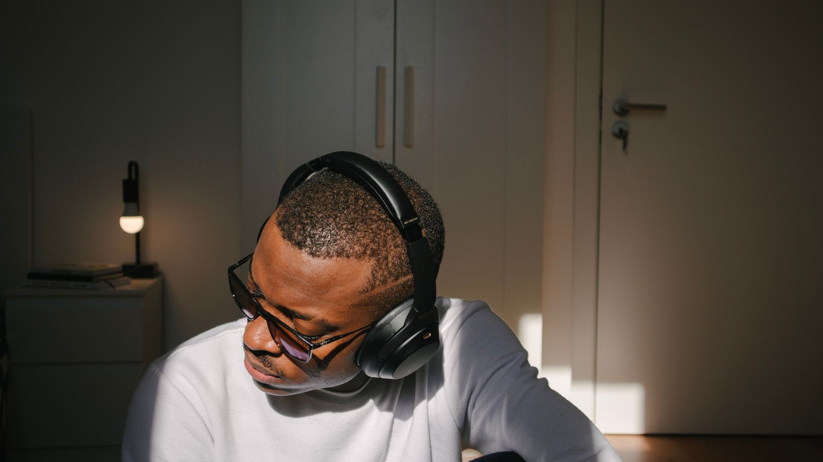 A man listening to music through headphones indoors