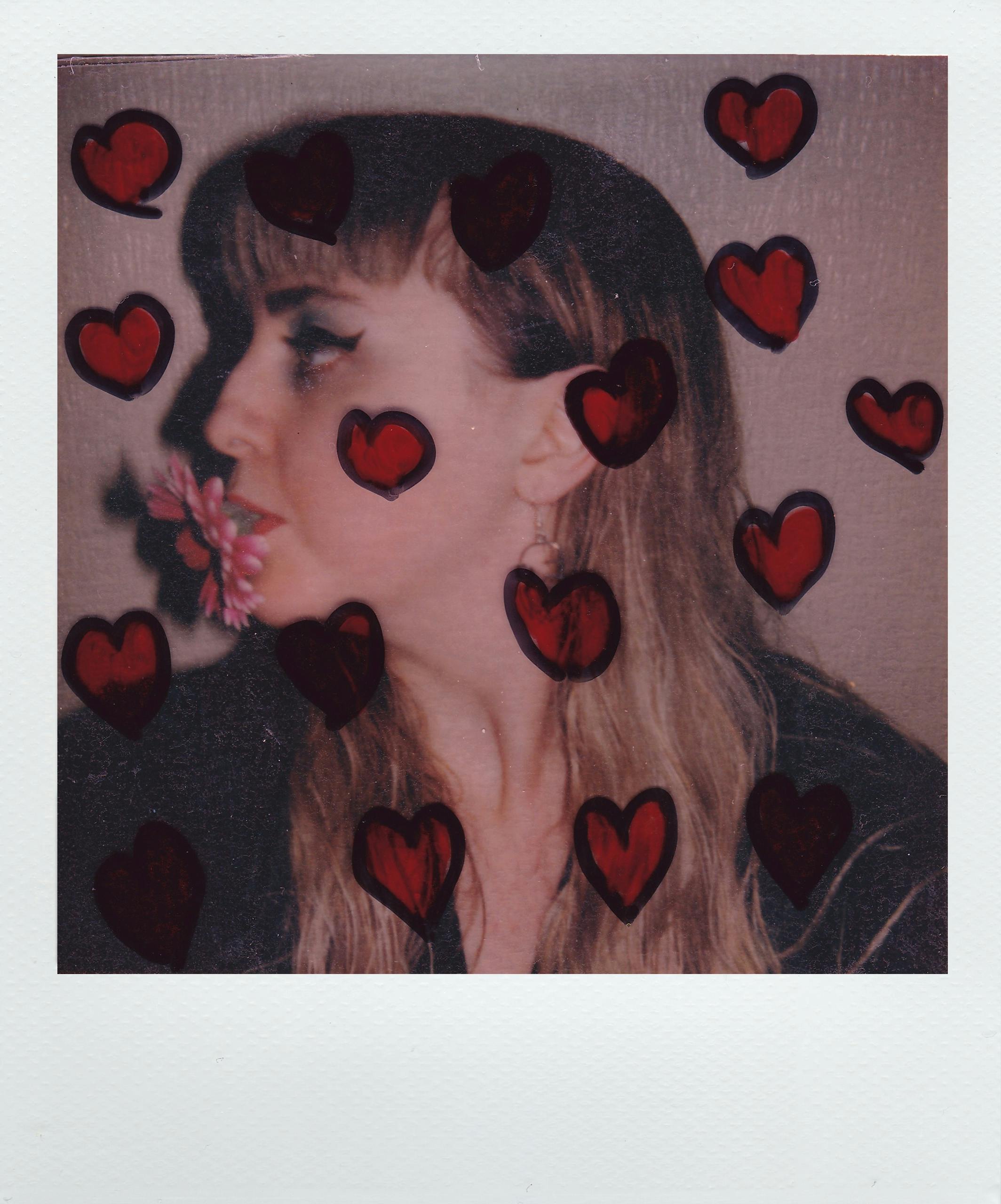 Artistic profile portrait with long hair surrounded by hand-drawn red hearts, featuring floral detail.
