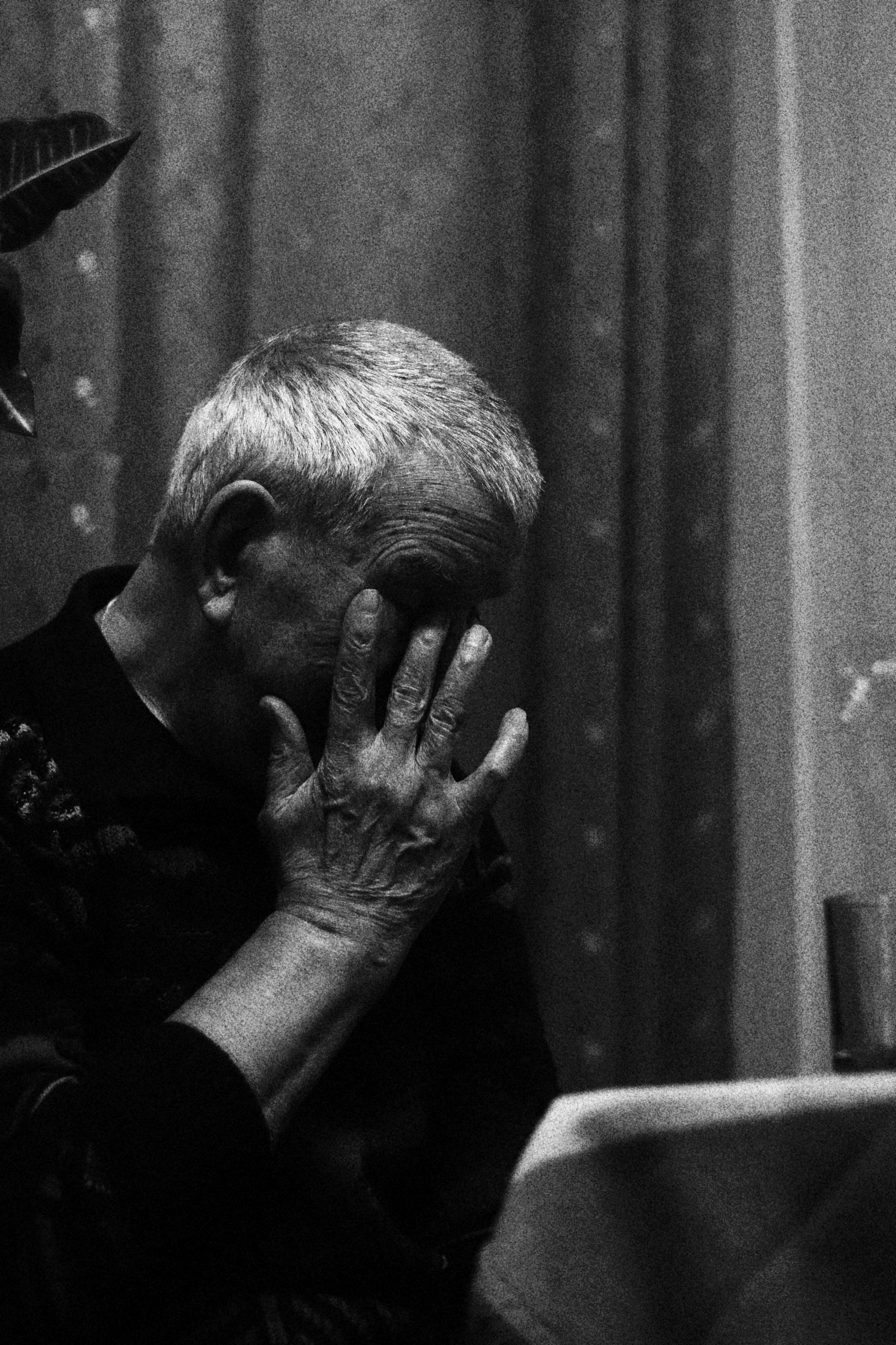 Reflective portrait of an elderly man in monochrome, capturing emotion and depth.