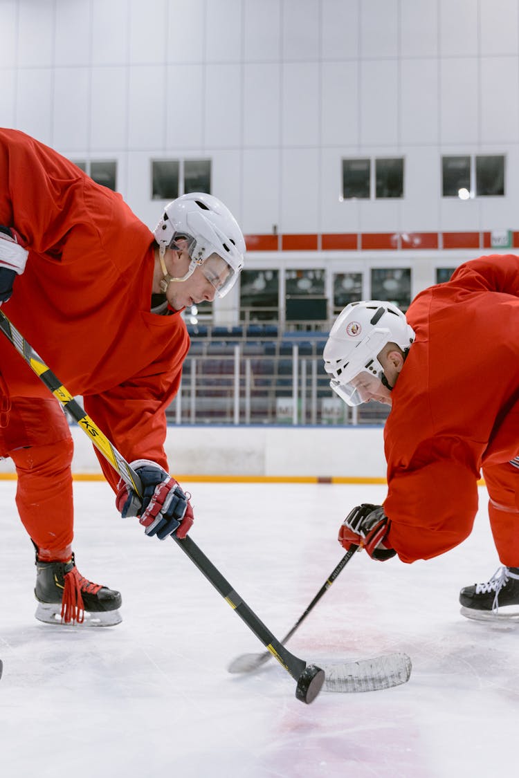 People In Red Uniform Playing Ice Hockey