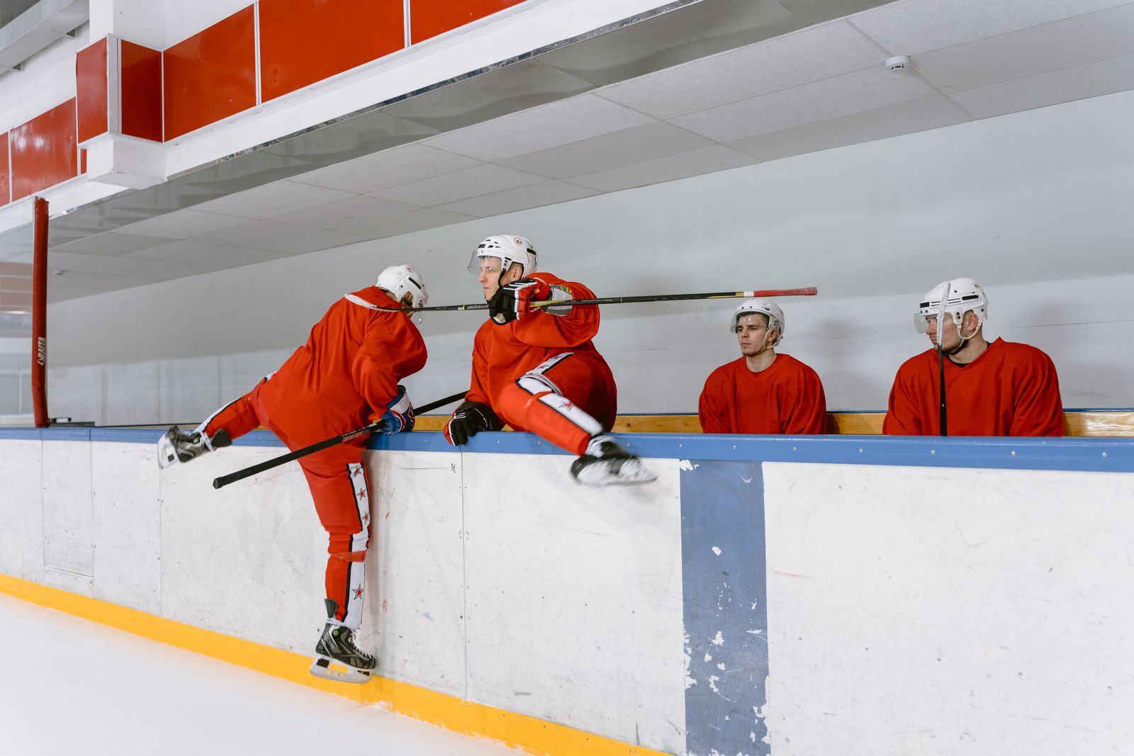 Ottermere players in red uniforms and white helmets training on the rink