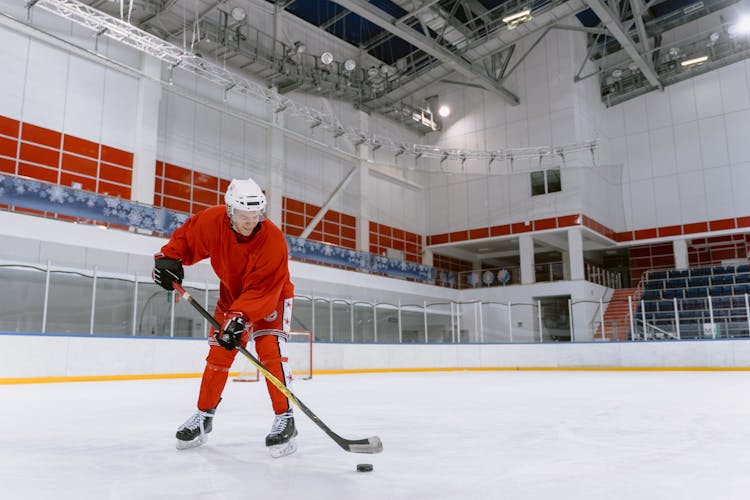 A Person In Red Uniform Playing Hockey 