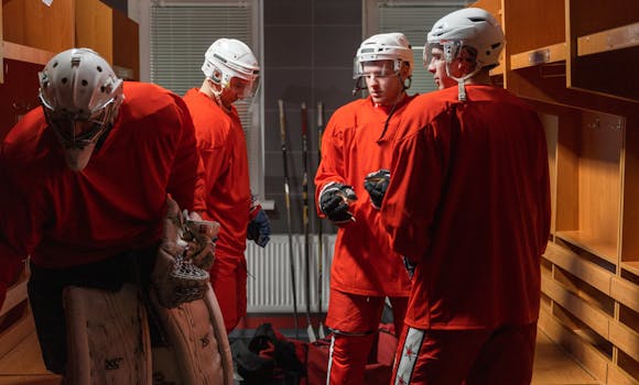 Ice hockey team in red uniforms preparing in the locker room before a game.