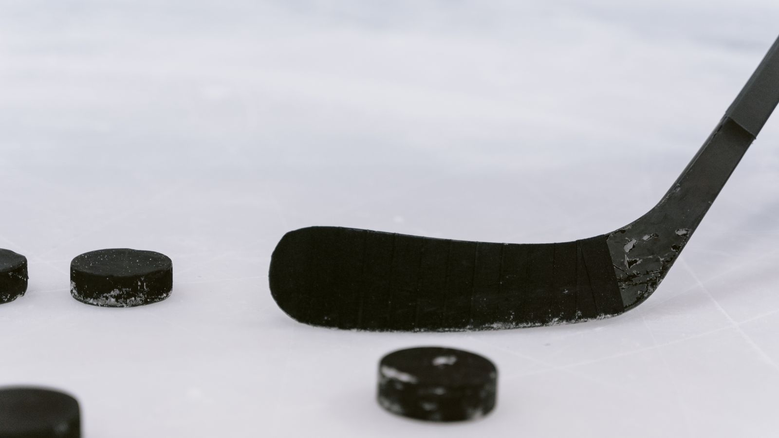 Representative licensed photograph of hockey pucks and a stick on ice; not the Hurricanes, Bruins or their October 27 NHL game