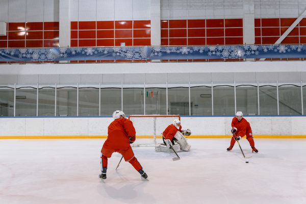 Three skaters running a shooting drill in an empty arena — photo by Tima Miroshnichenko on Pexels