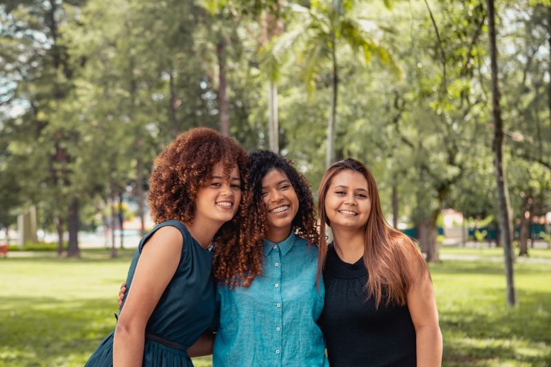 Três mulheres juntas em um parque