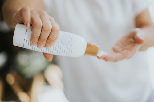 Person Holding White Soft Tube Bottle