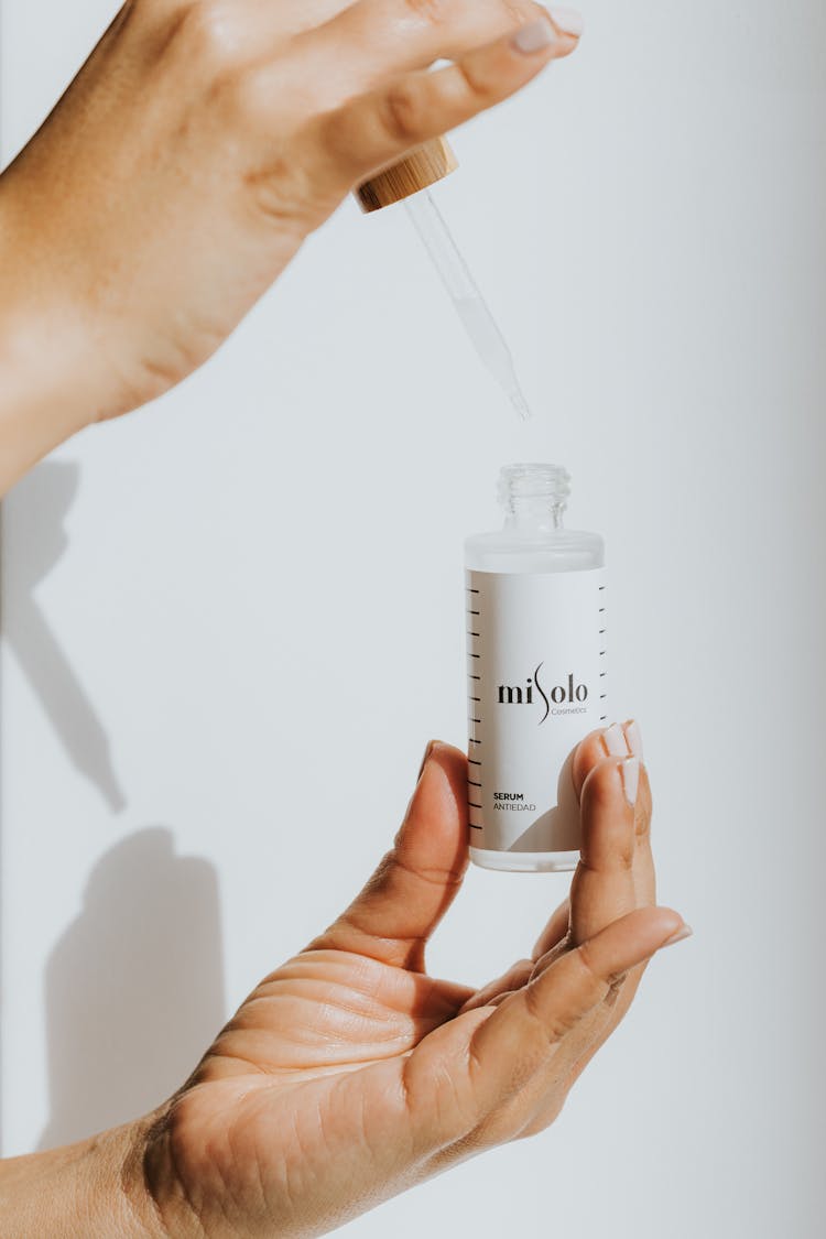 Person Holding A White Dropper Bottle