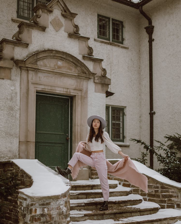 Trendy Young Asian Female Model Standing On Steps Of Aged House