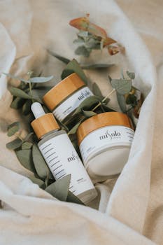 Natural cosmetic products with eucalyptus leaves on linen fabric for skincare routine.