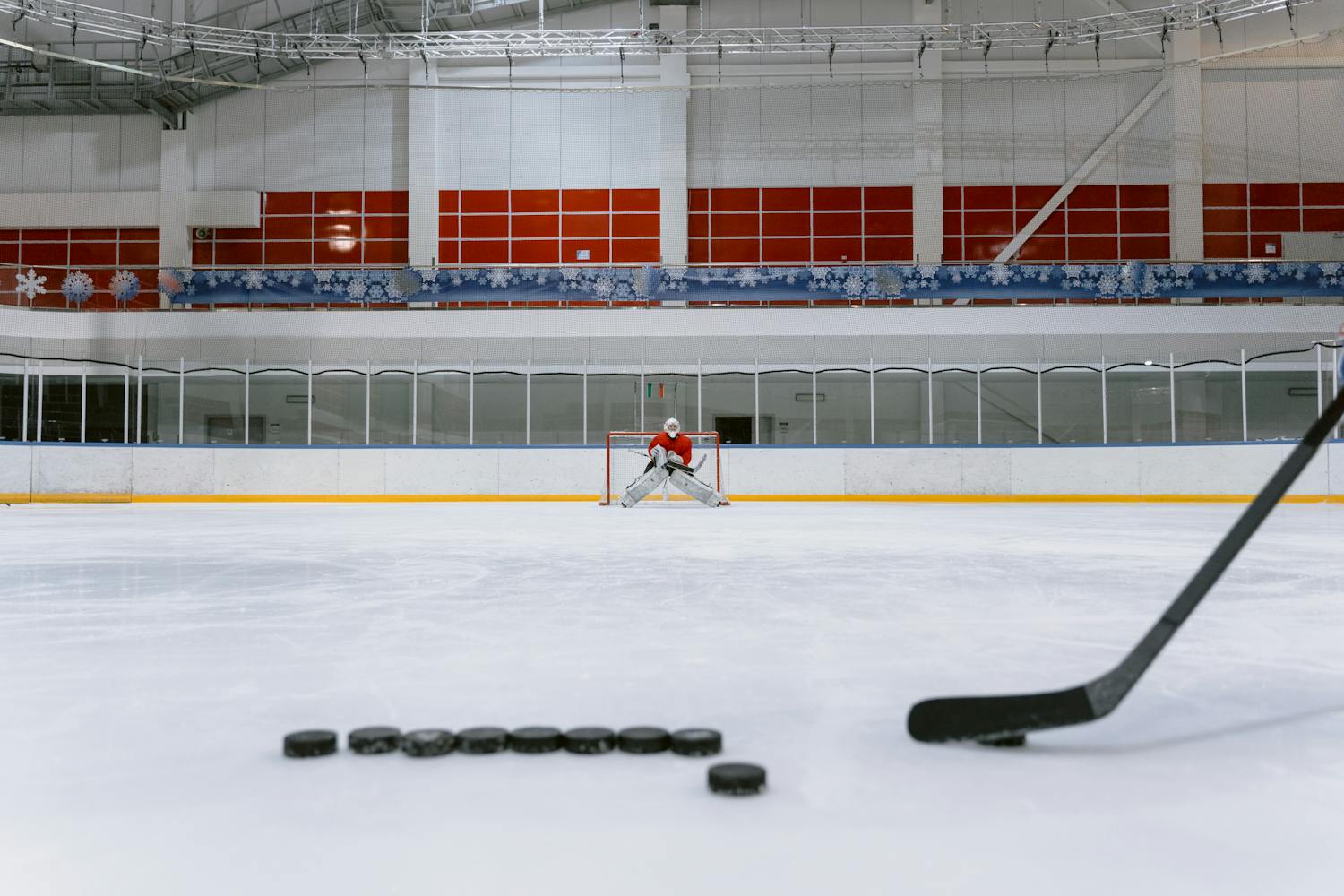 Ice hockey rink with a focused goalie preparing to stop the puck. Dynamic sports action.