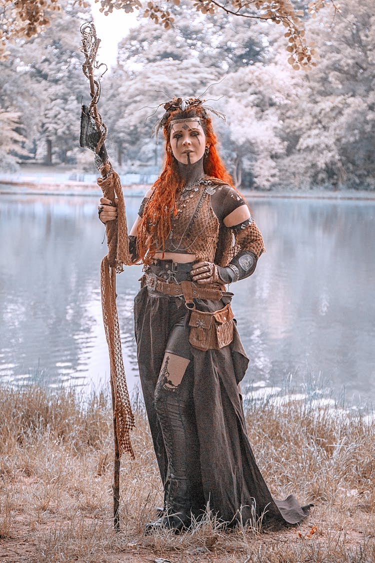 Woman In Medieval Costume Holding Brown Stick