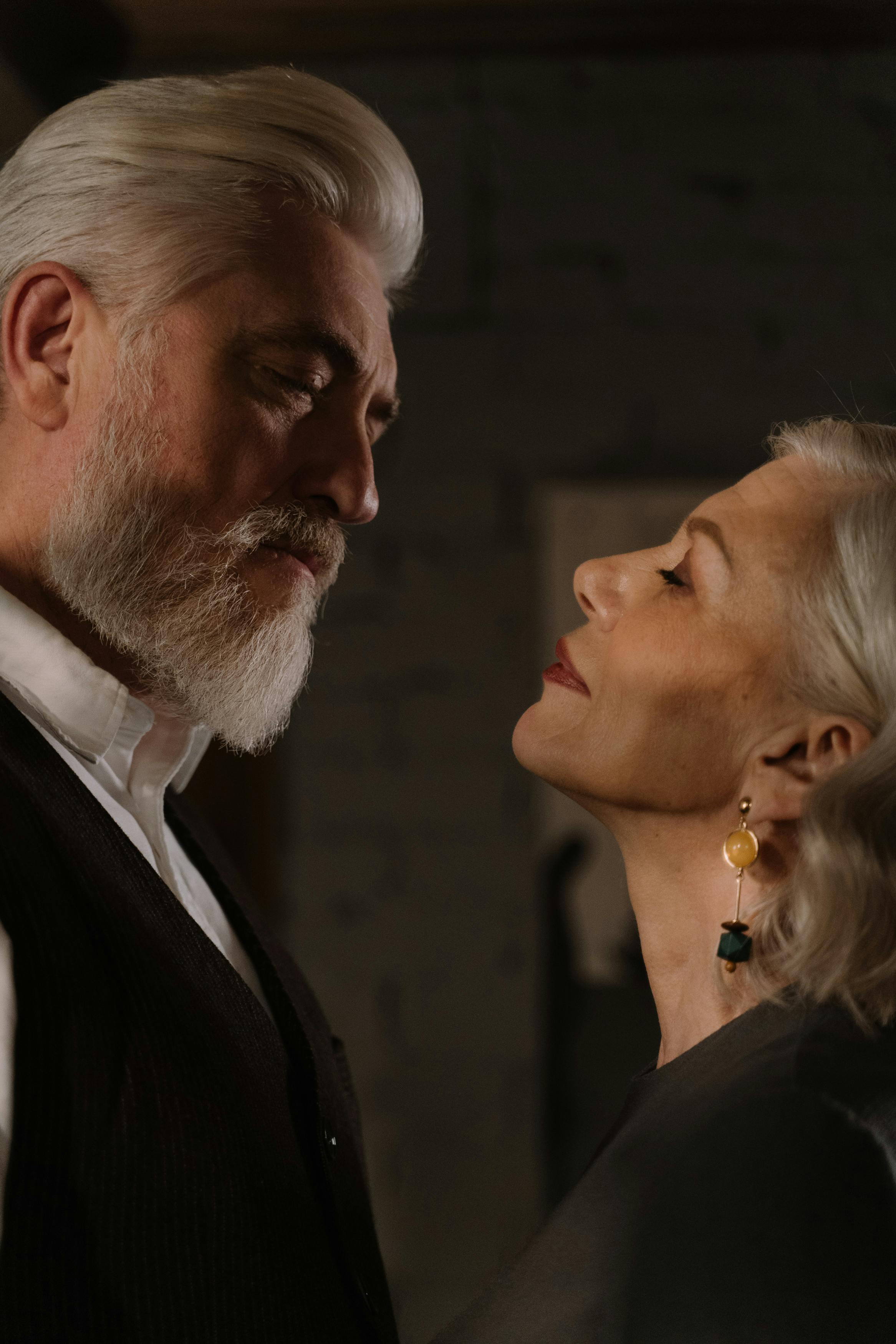 Senior couple sharing a romantic and elegant moment indoors, showcasing affection and timeless elegance.