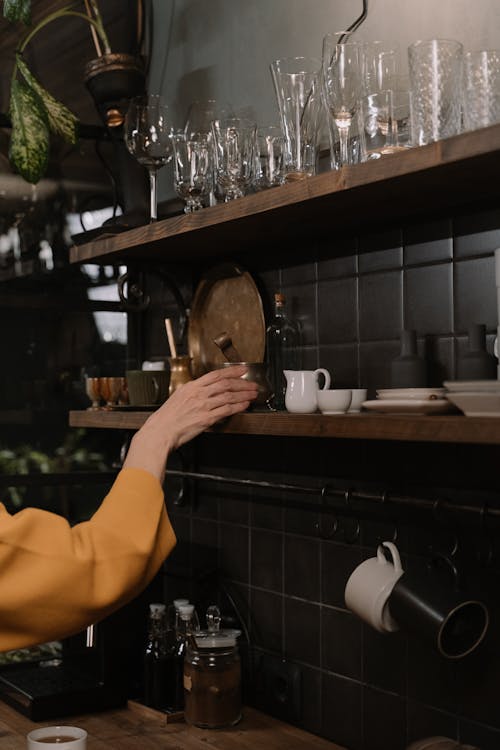 A Person Grabbing a Container from the Shelf