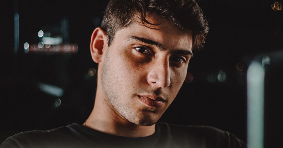 Moody night portrait of a young man with an intense, direct gaze