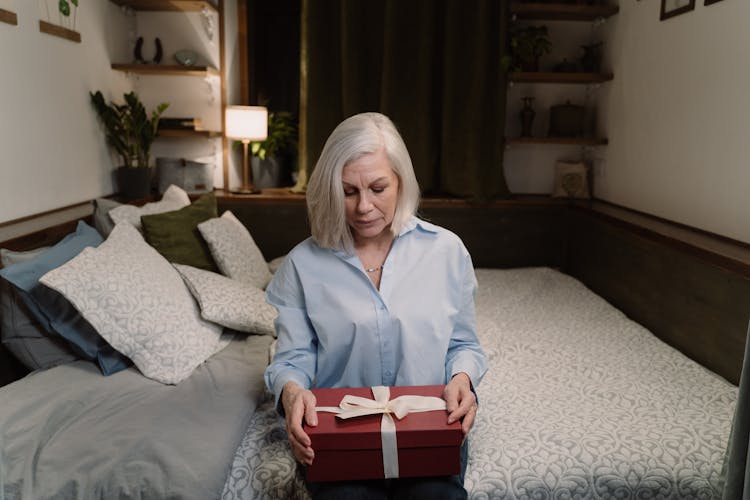 An Elderly Woman Holding A Present 